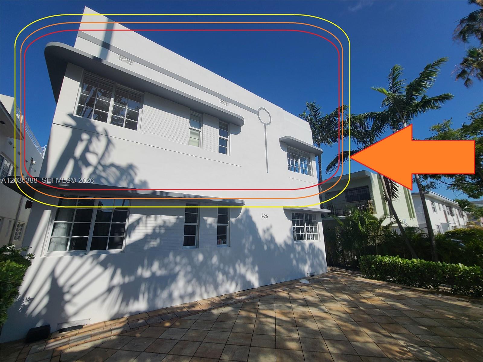 Exterior view of a two-story white Art Deco building with rounded corners and window awnings — 825 Michigan Ave # 3, Miami Beach FL 33139, MIAMI BEACH, FL