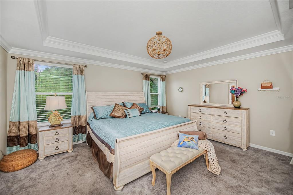 A bedroom features a light-colored wood bed frame, matching dresser, and blue bedding — 640 ENCARNACION STREET, PUNTA GORDA, FL