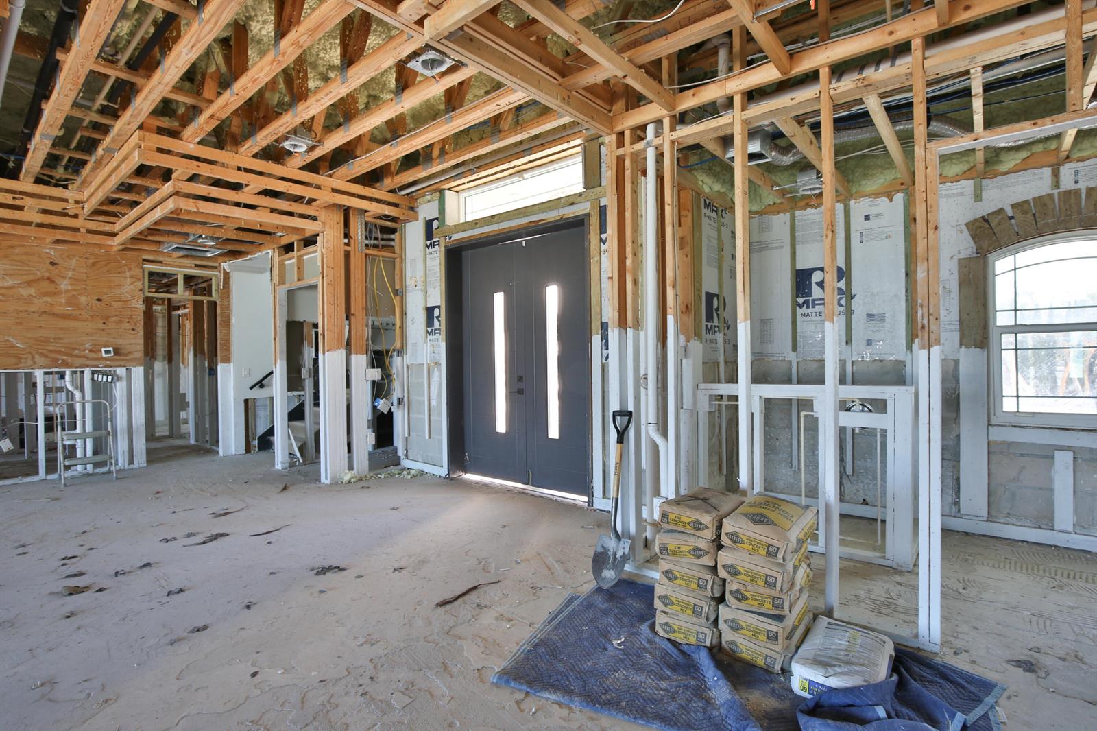 An interior view of a room under construction with exposed wooden framing and concrete floors — 7816 Sanderling Road, Sarasota FL 34242, SARASOTA, FL