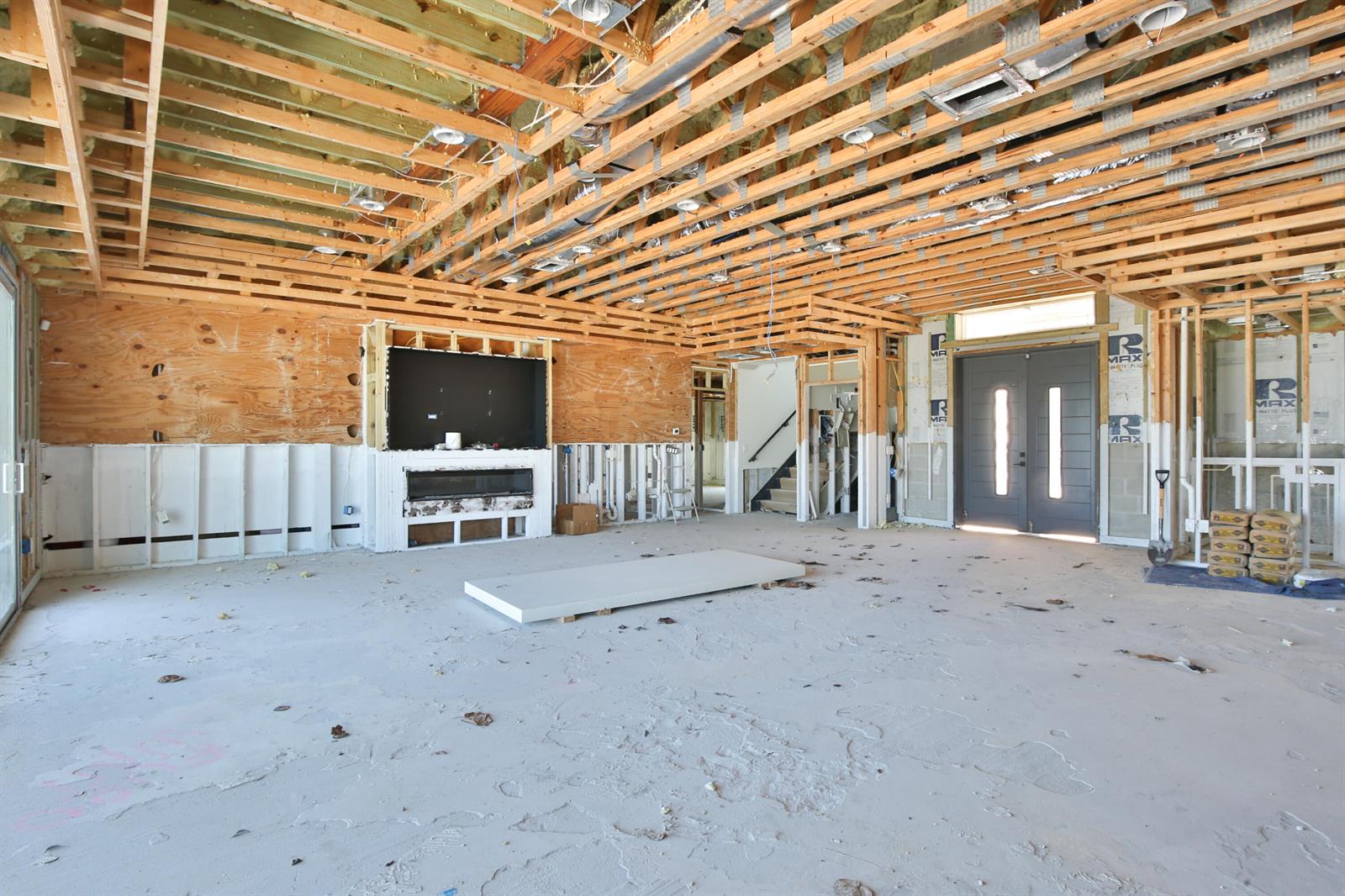 An unfinished room with exposed wood ceiling joists, a fireplace, and double entry doors — 7816 Sanderling Road, Sarasota FL 34242, SARASOTA, FL