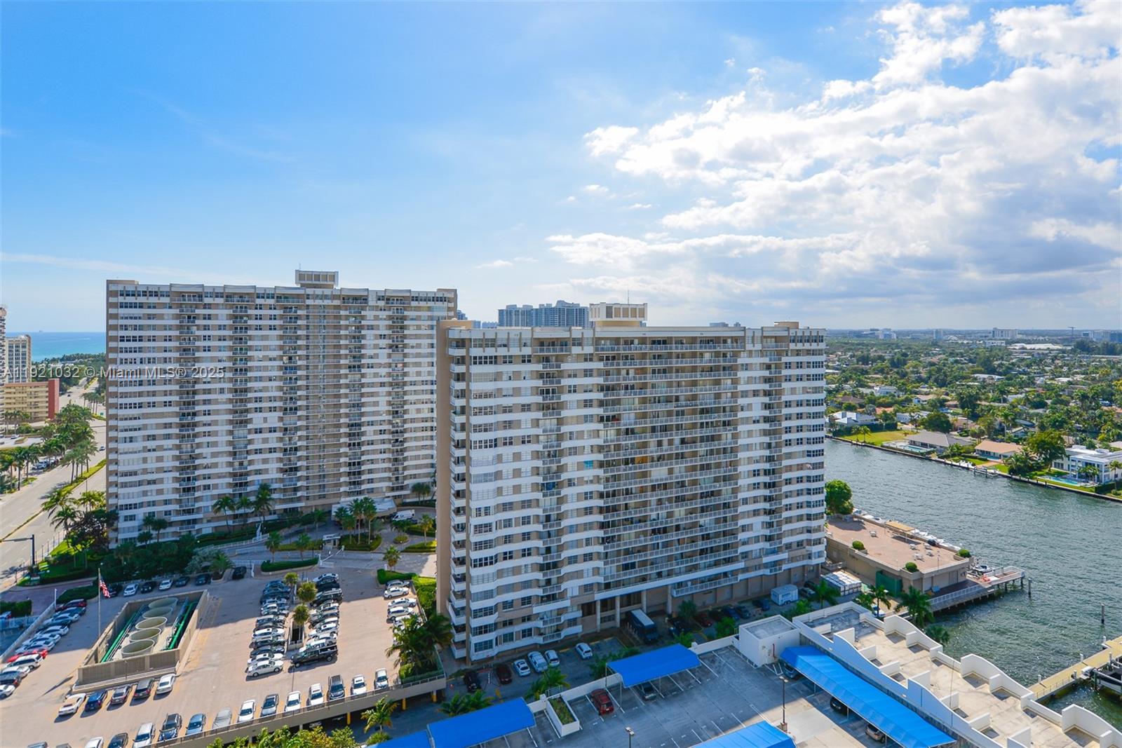 An aerial view shows two tall residential apartment buildings next to a waterway and parking — 1985 S Ocean Dr # 17H, Hallandale Beach FL 33009, HALLANDALE BEACH, FL