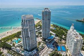An aerial view shows three high-rise residential towers situated along a sandy beach and ocean — 100 S Pointe Dr # 3702, Miami Beach FL 33139, MIAMI BEACH, FL