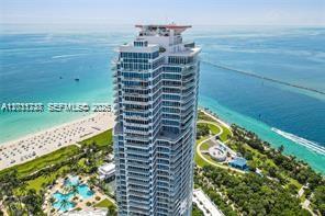 An aerial view shows a tall residential skyscraper situated on a beach near the ocean — 100 S Pointe Dr # 3702, Miami Beach FL 33139, MIAMI BEACH, FL
