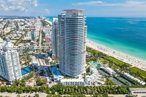 An aerial view shows a tall, cylindrical residential tower situated on a beach in Miami — 100 S Pointe Dr # 3702, Miami Beach FL 33139, MIAMI BEACH, FL