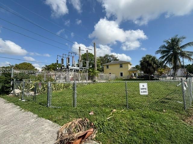 A fenced lot with an electrical substation sits in front of a yellow two-story house — 193 NW 16th St, Miami FL 33136, MIAMI, FL