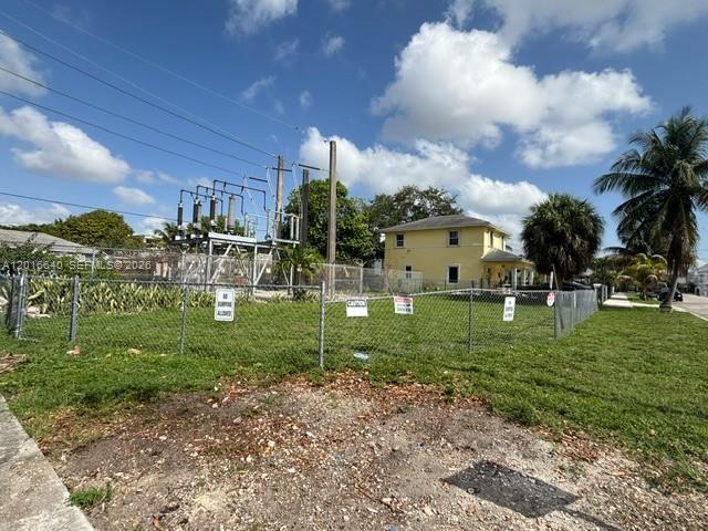 A fenced lot with an electrical substation sits next to a two-story yellow house — 193 NW 16th St, Miami FL 33136, MIAMI, FL