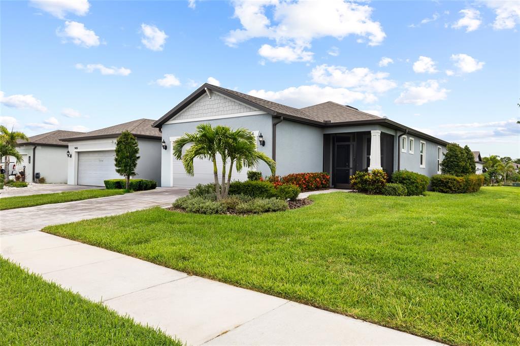 A light blue single-story house with a two-car garage and a landscaped front yard — 9454 BALLASTER POINTE LOOP, PARRISH, FL