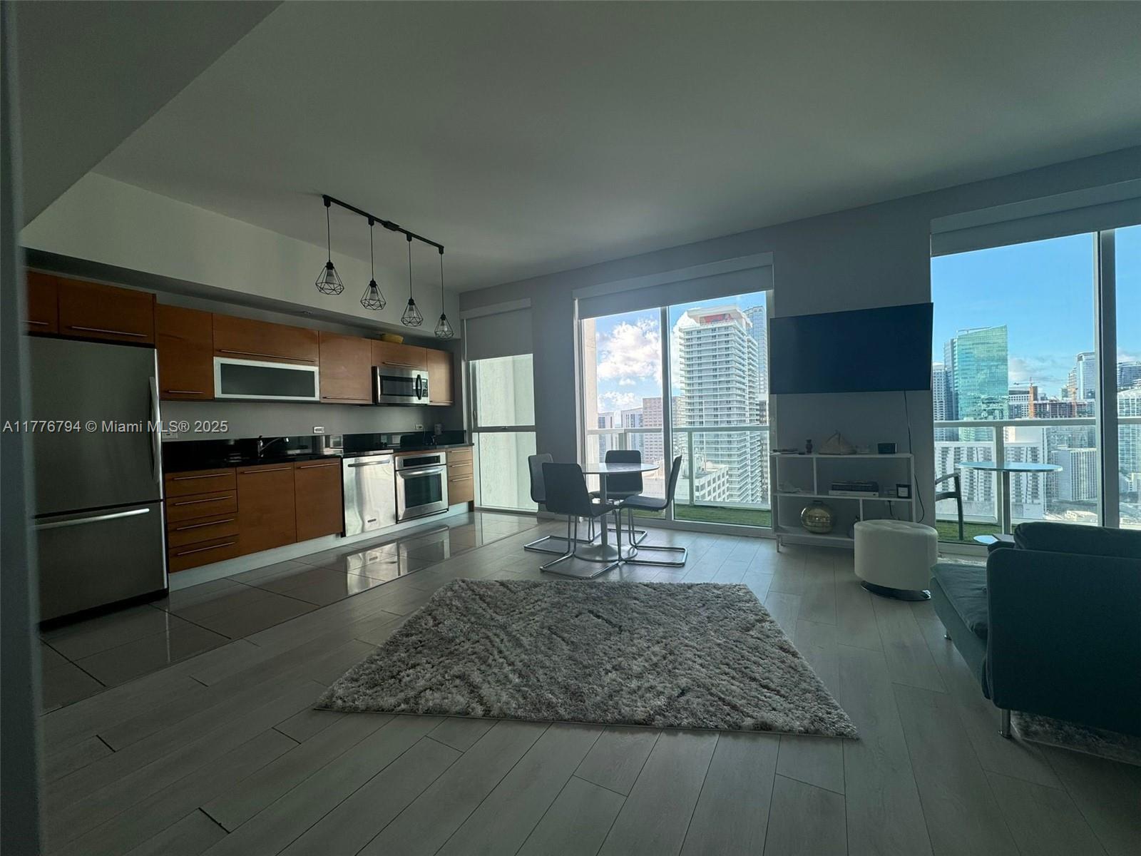 A modern apartment features an open-concept kitchen, dining area, and living space with city views — 244 Biscayne Blvd # 3905, Miami FL 33132, MIAMI, FL