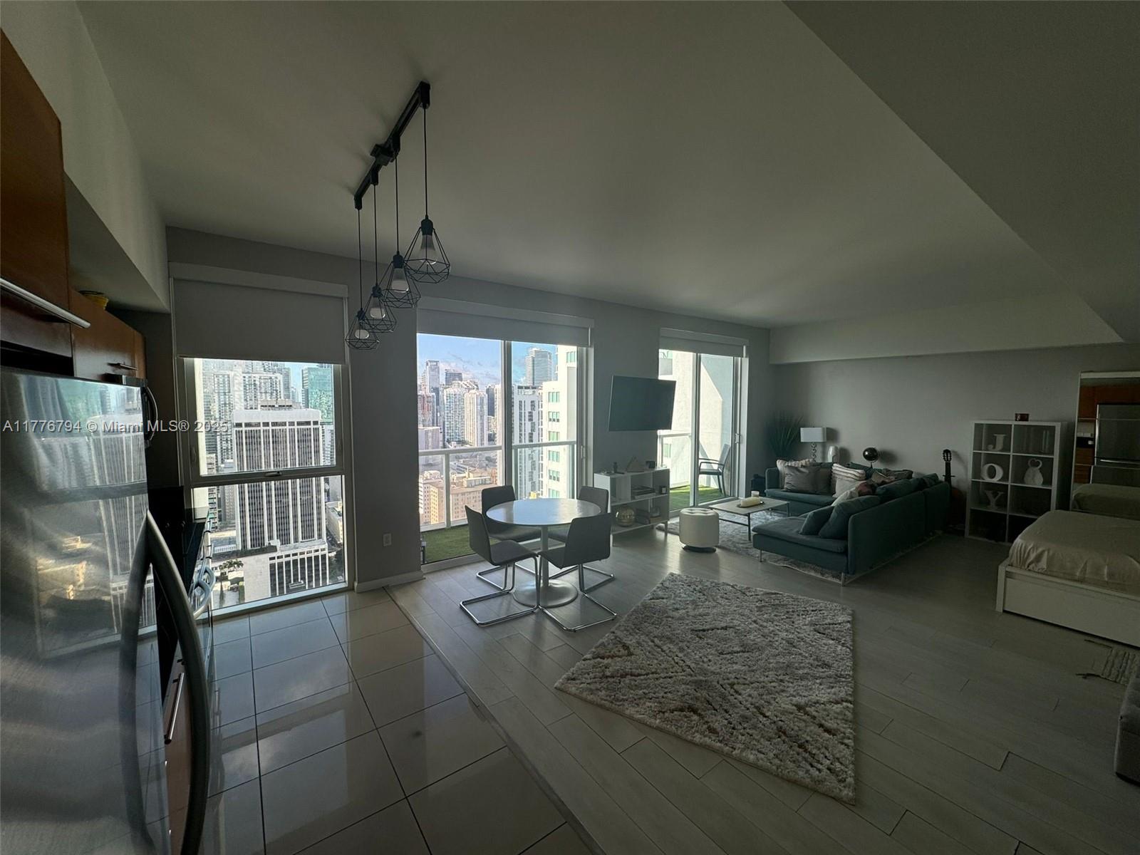 An open-concept apartment features a kitchen, dining area, living room, and floor-to-ceiling city views — 244 Biscayne Blvd # 3905, Miami FL 33132, MIAMI, FL