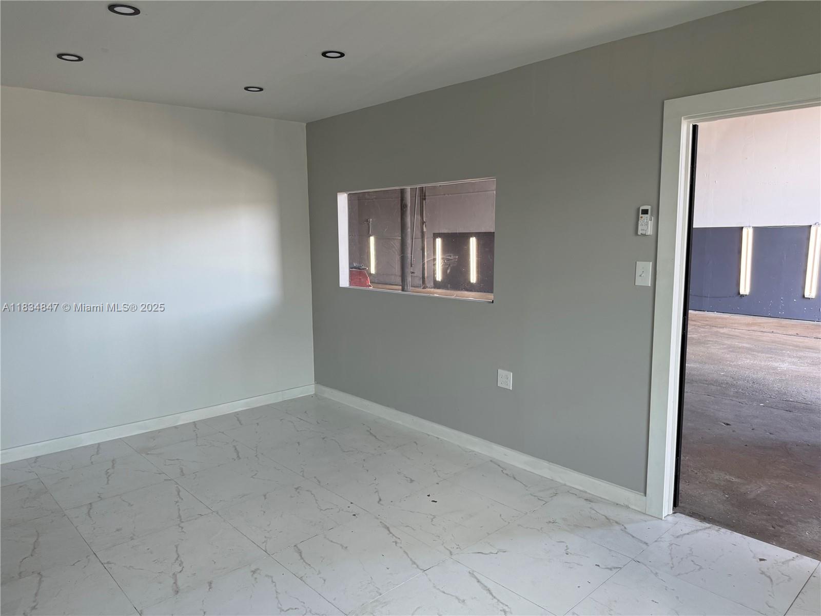 An interior room features white marble-look tile floors, gray walls, and a rectangular pass-through window — 3771 NW 51st St # B, Hialeah FL 33142, HIALEAH, FL