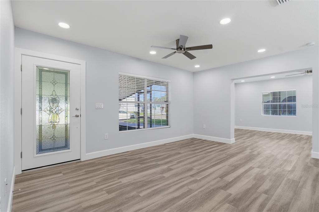 A bright living room features light gray walls, wood-look flooring, a ceiling fan, and recessed lighting — 4509 26TH AVENUE S, TAMPA, FL