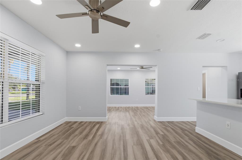 An interior view of a room with light gray walls, wood-look flooring, and a ceiling fan — 4509 26TH AVENUE S, TAMPA, FL