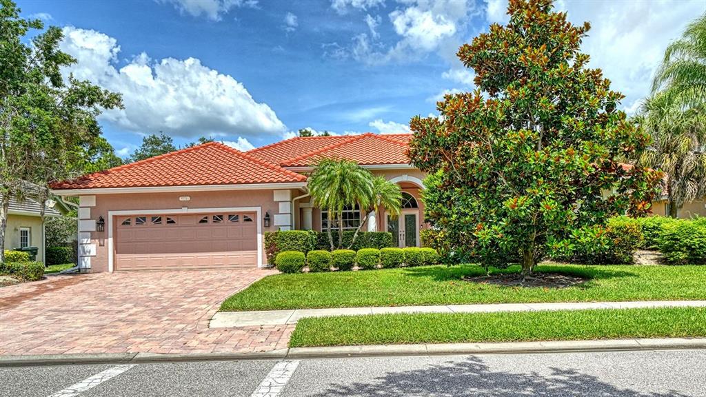 A single-story house with a terracotta tile roof and a paved driveway — 4769 SWEETMEADOW CIRCLE, SARASOTA, FL