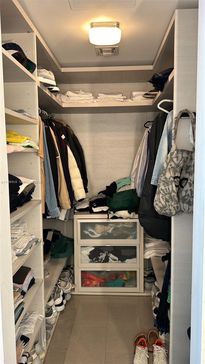 A walk-in closet features built-in shelving, a three-drawer unit, and hanging space for clothing — 88 SW 7th St # 810, Miami FL 33130, MIAMI, FL