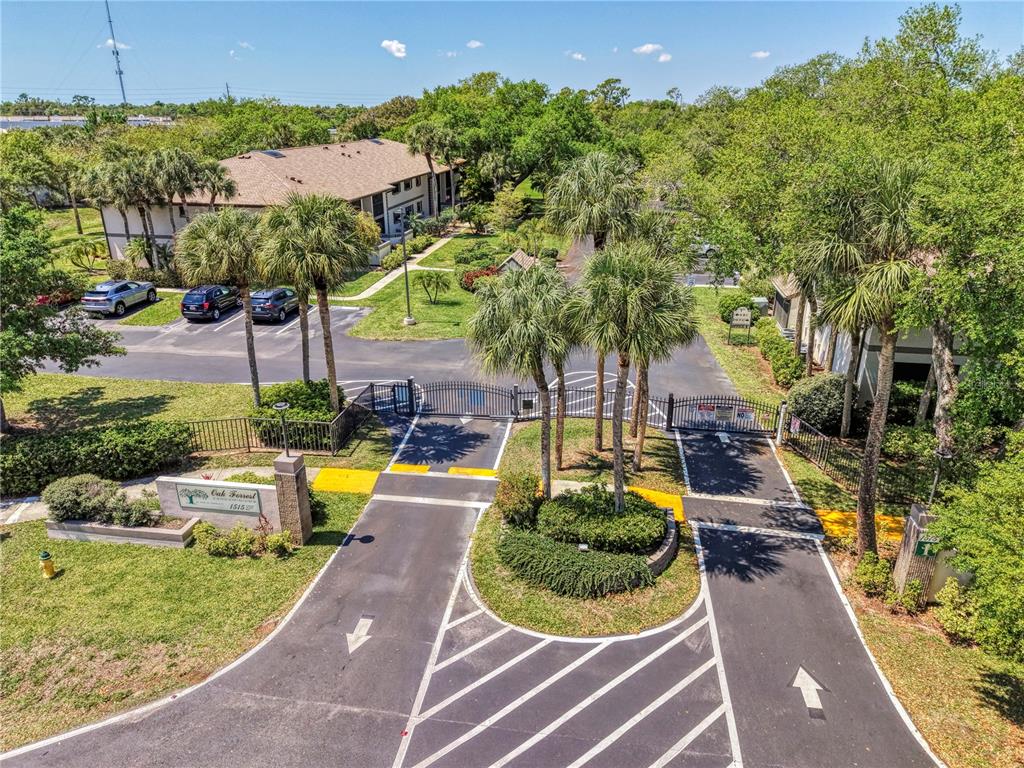 An aerial view shows the gated entrance to a residential complex with palm trees — 1515 FORREST NELSON BOULEVARD UNIT G104, PORT CHARLOTTE, FL