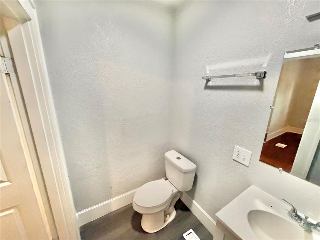 A small bathroom features a white toilet, a vanity sink, and a wall-mounted towel bar — 4700 10TH AVENUE S, ST PETERSBURG, FL