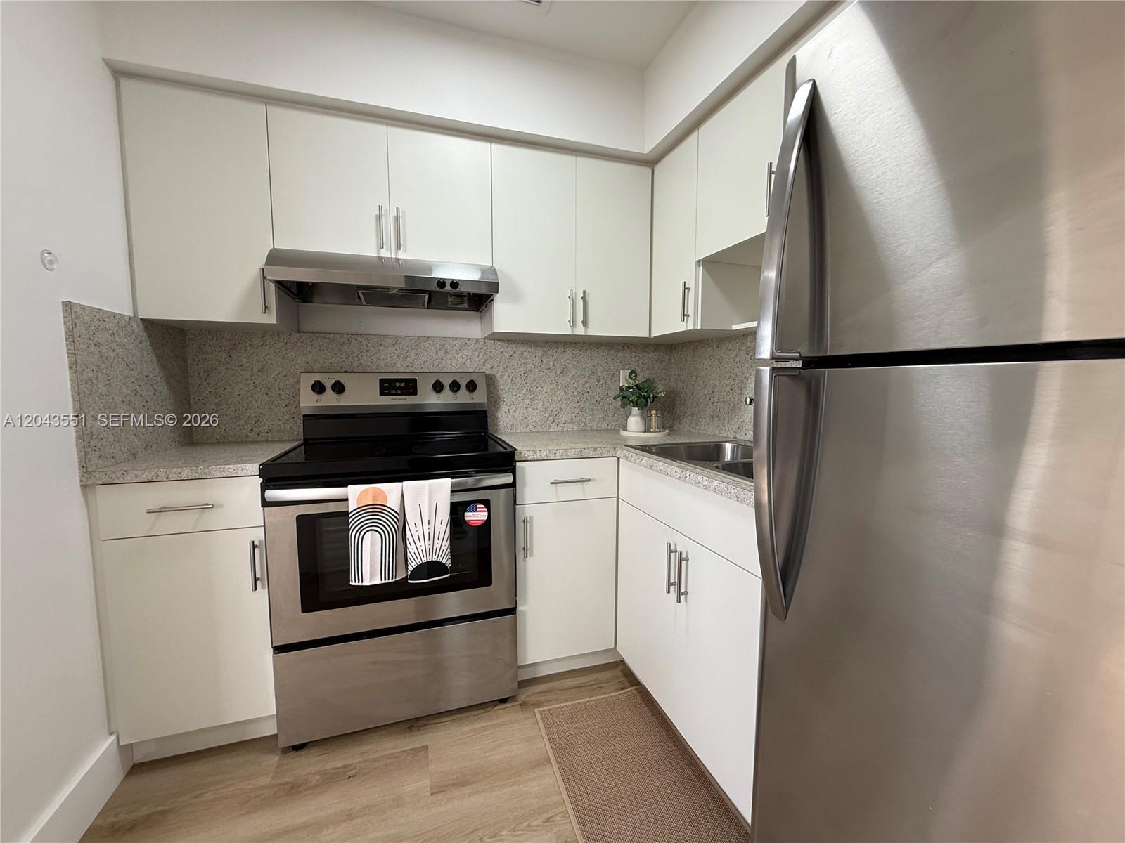 A kitchen features white cabinets, stainless steel appliances, and speckled countertops — 8860 SW 32nd st, Miami FL 33165, MIAMI, FL