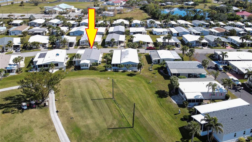 An aerial view shows a residential neighborhood with a yellow arrow pointing to a house — 2100 KINGS HIGHWAY UNIT 364, PORT CHARLOTTE, FL