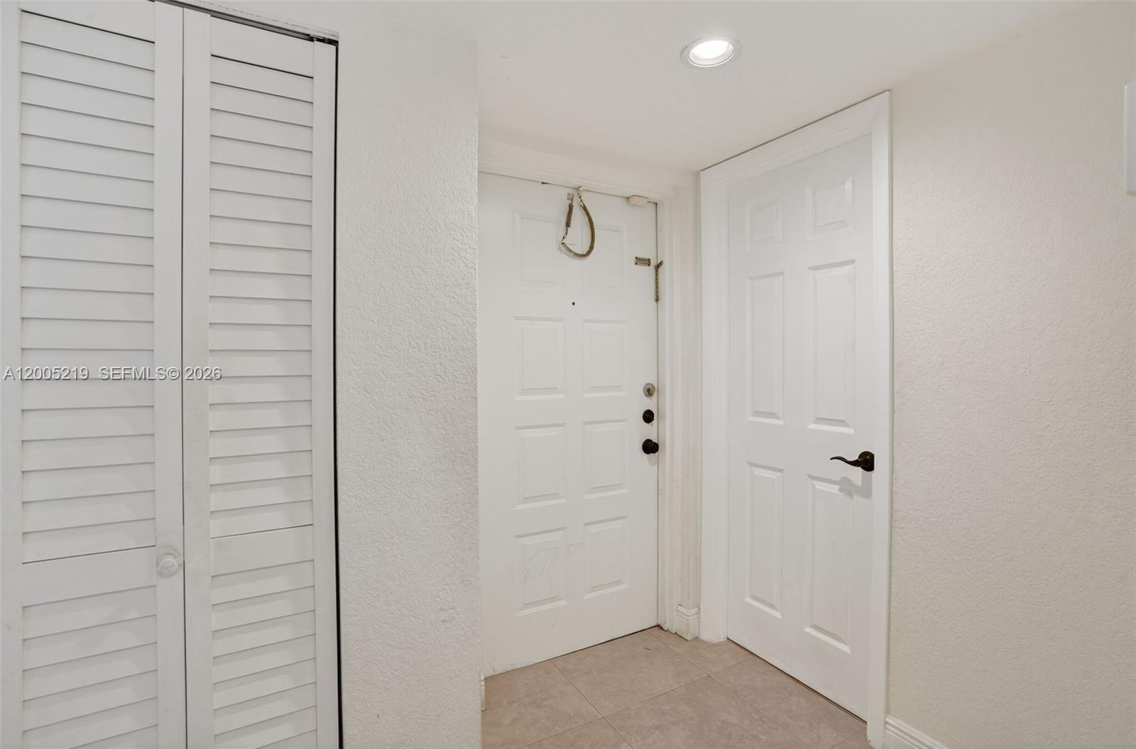 An entryway features a white front door, a closet with louvered doors, and a side door — 845 NW 91st Ter, Plantation FL 33324, PLANTATION, FL