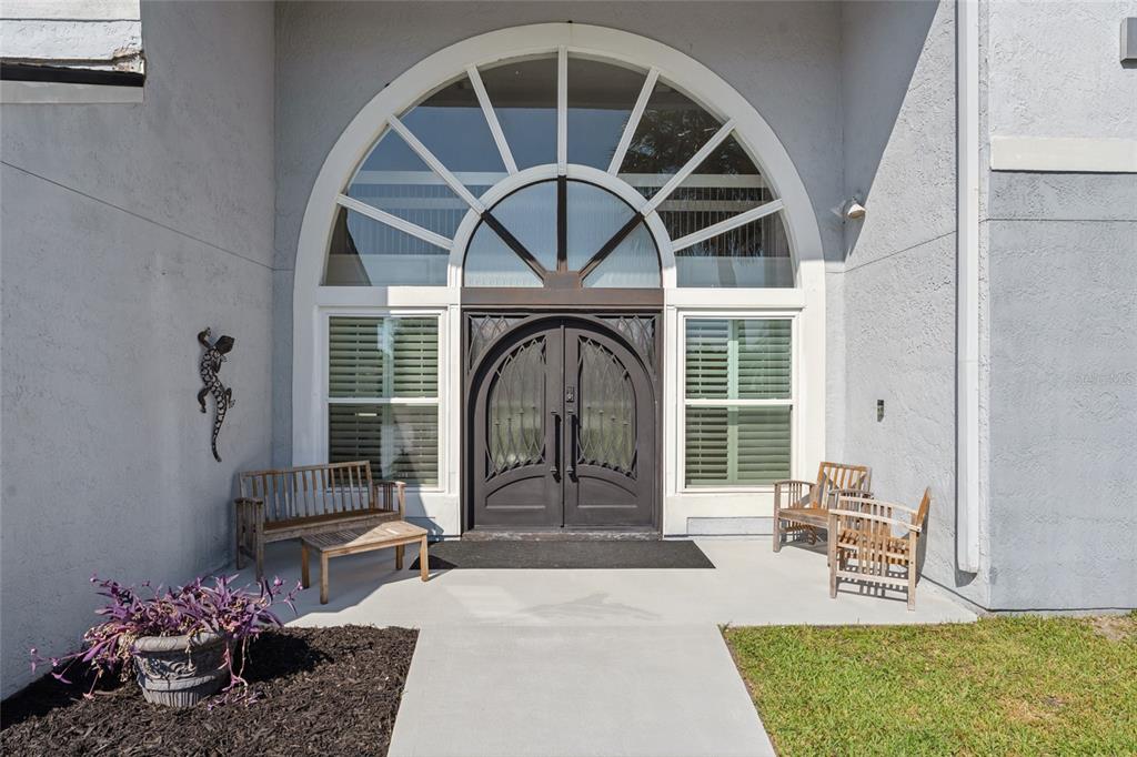 A bright entryway features a stone fireplace, a built-in mudroom bench, and double black doors — 2484 ALBANY DRIVE, KISSIMMEE, FL