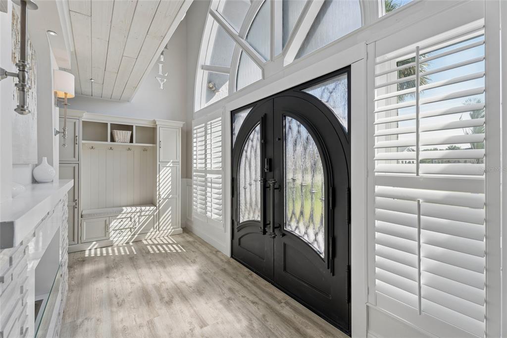 A modern kitchen features white cabinetry, a large stone-topped island, stainless steel appliances, and stools — 2484 ALBANY DRIVE, KISSIMMEE, FL