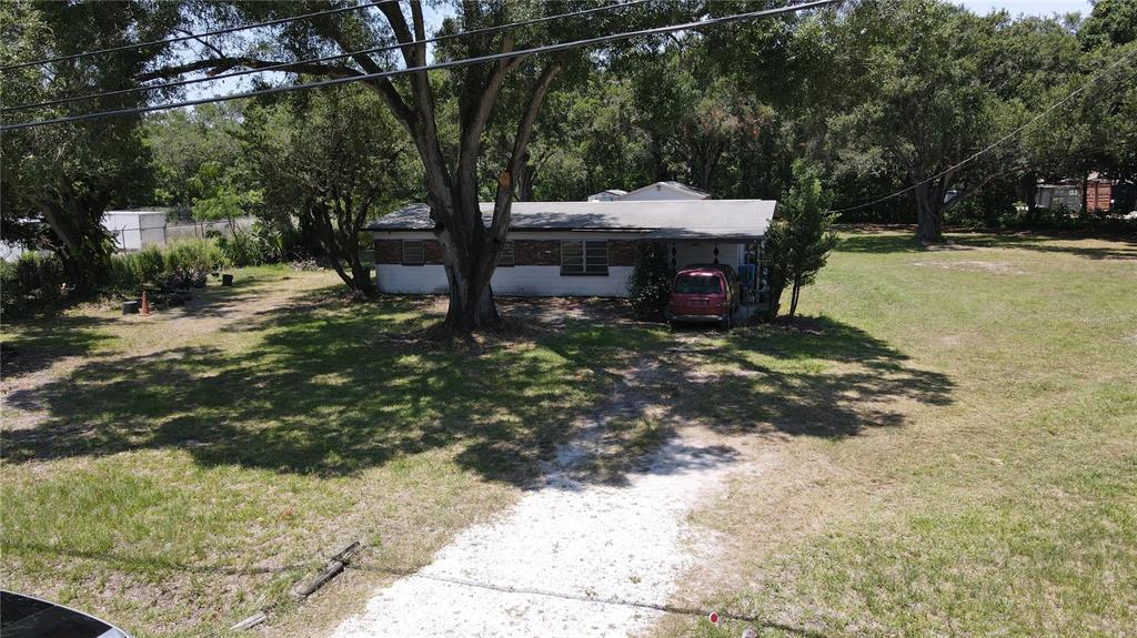 An aerial view shows a single-story house with a gravel driveway and large shade trees — 1406 HOBBS STREET, TAMPA, FL
