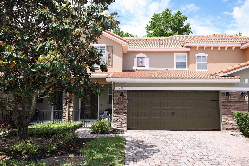 A two-story house with a brown garage, tile roof, and a paved driveway — 632 VENICE PLACE, SANFORD, FL