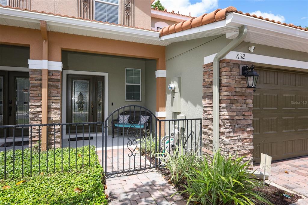 The exterior of a house features a stone-accented garage, a gated courtyard, and a front door — 632 VENICE PLACE, SANFORD, FL
