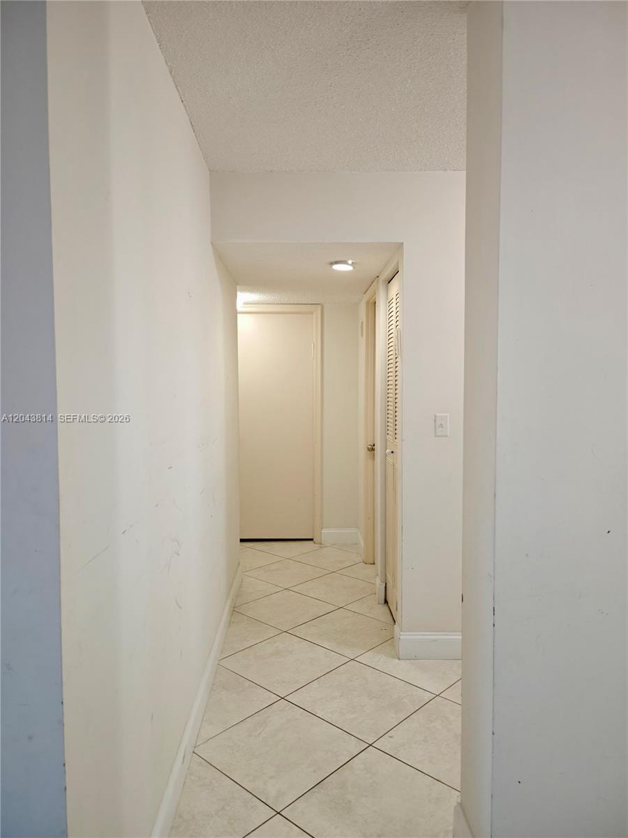 A narrow hallway features white walls, a tiled floor, and two closed interior doors — 400 NE 12th Ave # 306, Hallandale Beach FL 33009, HALLANDALE BEACH, FL