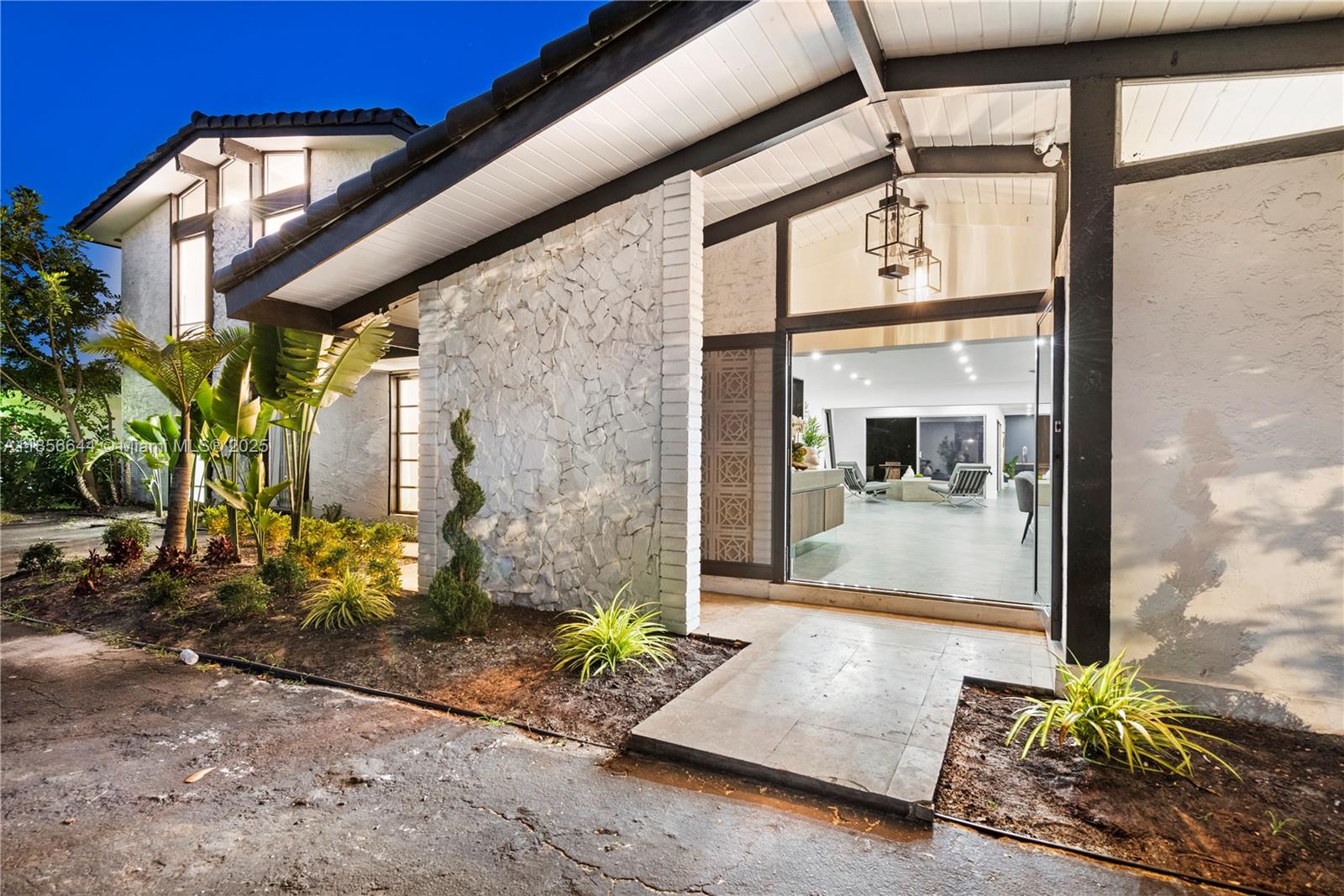 The exterior of a modern home features a stone accent wall and a glass entryway — 4322 Polk St, Hollywood FL 33021, HOLLYWOOD, FL