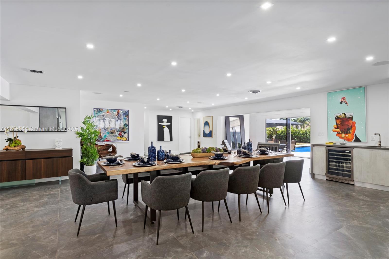 A dining room features a long wooden table, gray chairs, and a built-in wine cooler — 4322 Polk St, Hollywood FL 33021, HOLLYWOOD, FL
