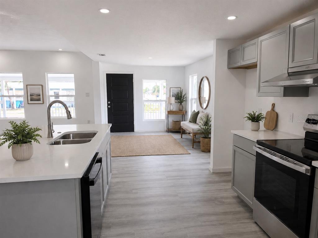 A kitchen with gray cabinets, white countertops, and a central island overlooks an entryway — 201 DR J A WILTSHIRE AVENUE W, LAKE WALES, FL