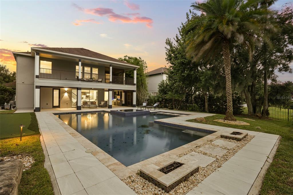 A two-story house exterior features a swimming pool, a covered patio, and a palm tree — 16038 JOHNS LAKE OVERLOOK DRIVE, WINTER GARDEN, FL