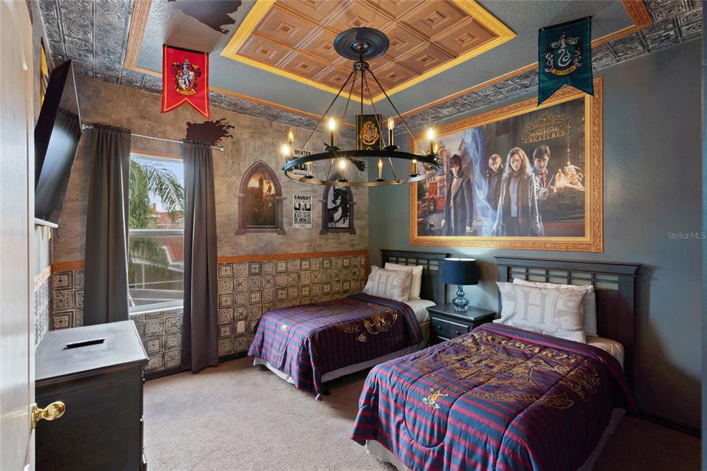 A Harry Potter-themed bedroom features two twin beds, a chandelier, and decorative wall murals — 730 BRUNELLO DRIVE, DAVENPORT, FL
