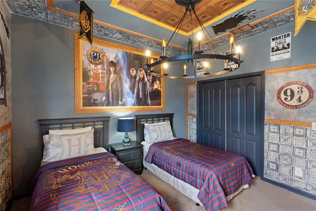 A Harry Potter-themed bedroom features two twin beds, a chandelier, and decorative wall murals — 730 BRUNELLO DRIVE, DAVENPORT, FL