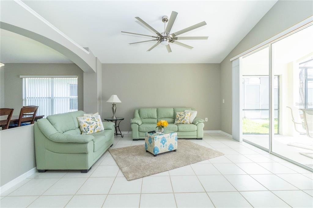 A living room features light green sofas, a patterned ottoman, and tile flooring — 1057 SOARING EAGLE LANE, KISSIMMEE, FL
