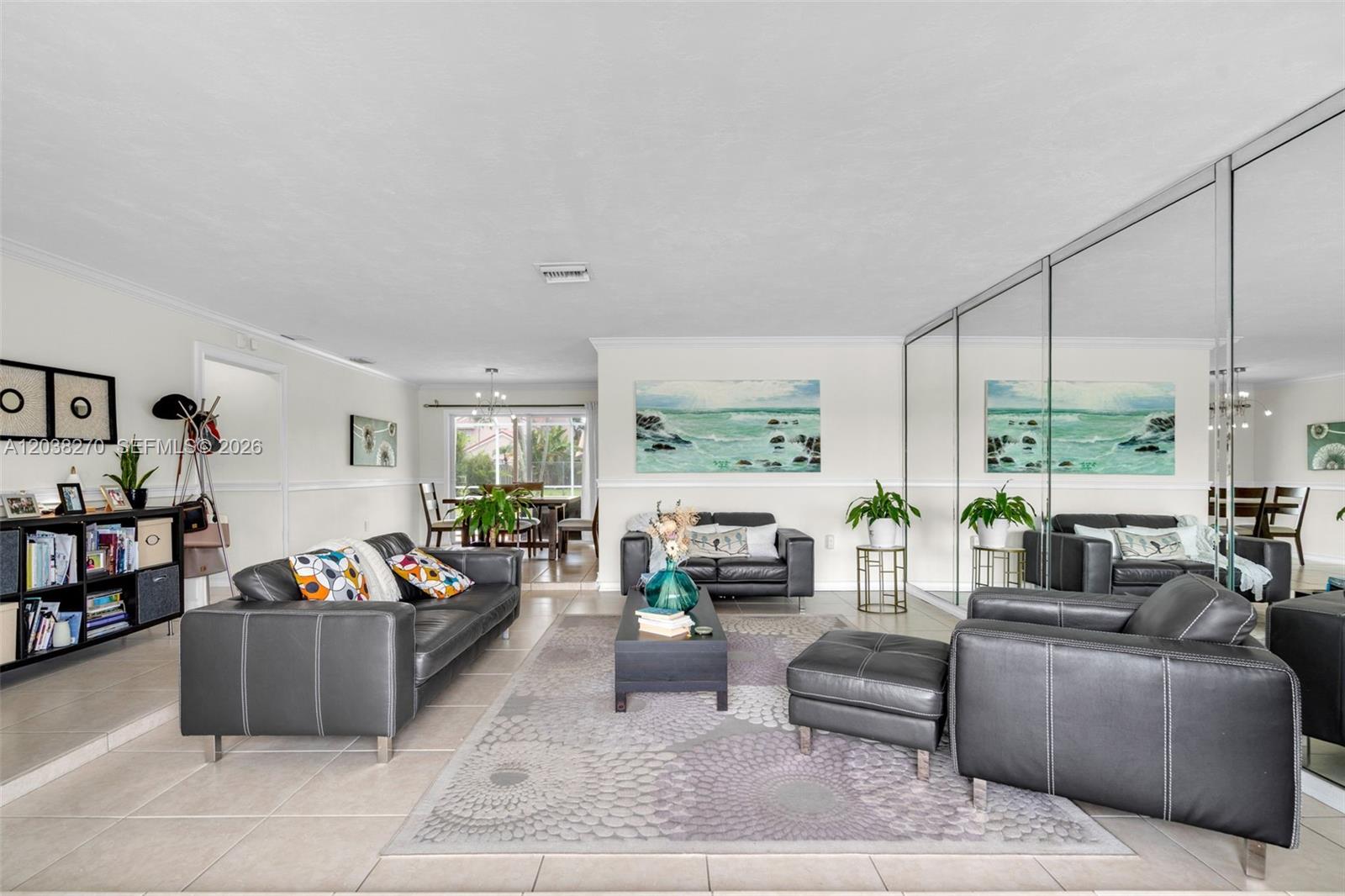 A living room features dark leather furniture, a patterned area rug, and a mirrored wall — 9624 NW 19th Pl, Sunrise FL 33322, SUNRISE, FL
