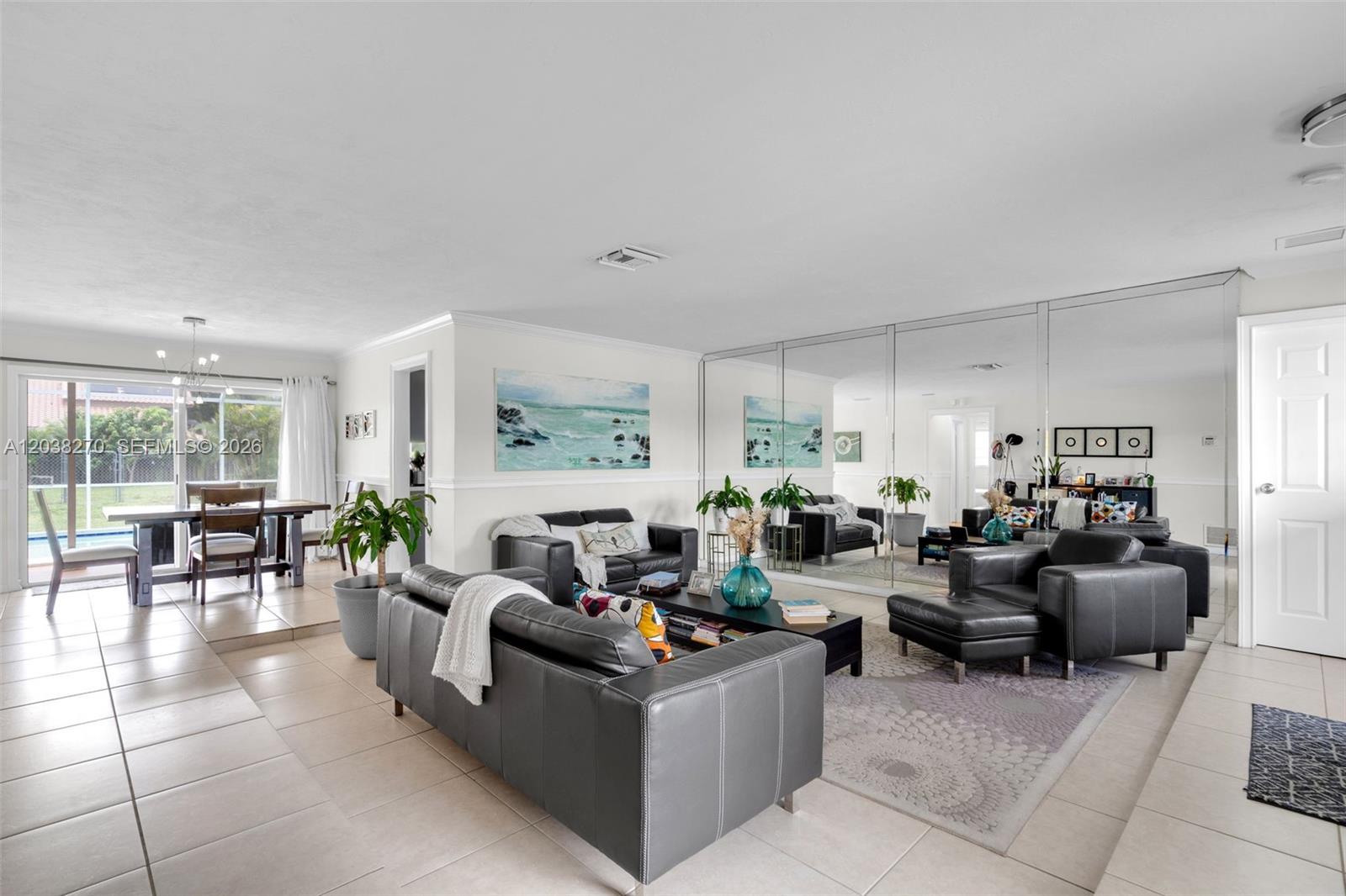 A living room features dark leather furniture, a mirrored wall, and an adjacent dining area — 9624 NW 19th Pl, Sunrise FL 33322, SUNRISE, FL