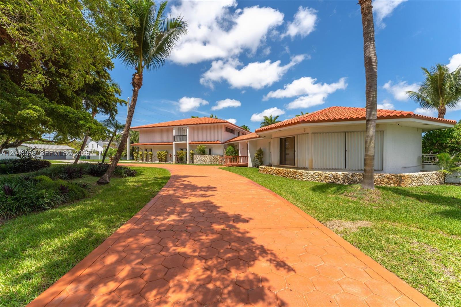 A paved driveway leads to a two-story house with a tiled roof and palm trees — 8390 SW 2nd St # 0, Miami FL 33144, MIAMI, FL