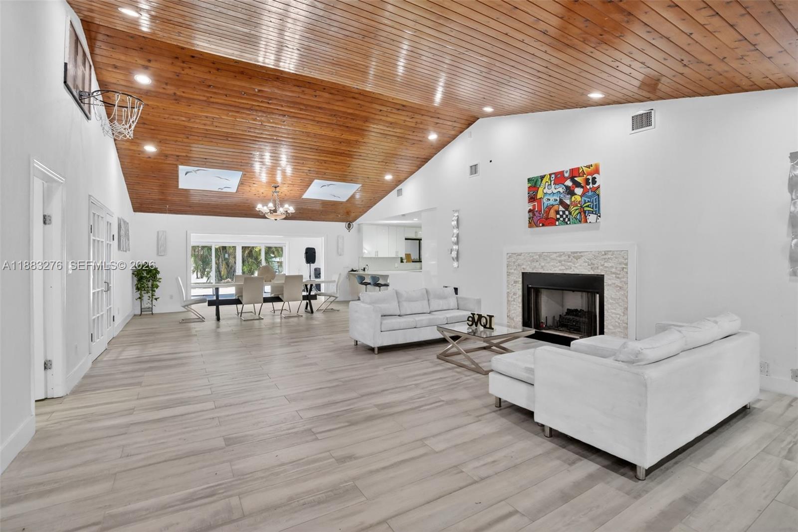 A spacious living and dining area features a vaulted wood-paneled ceiling and fireplace — 14401 SW 23rd St, Davie FL 33325, DAVIE, FL
