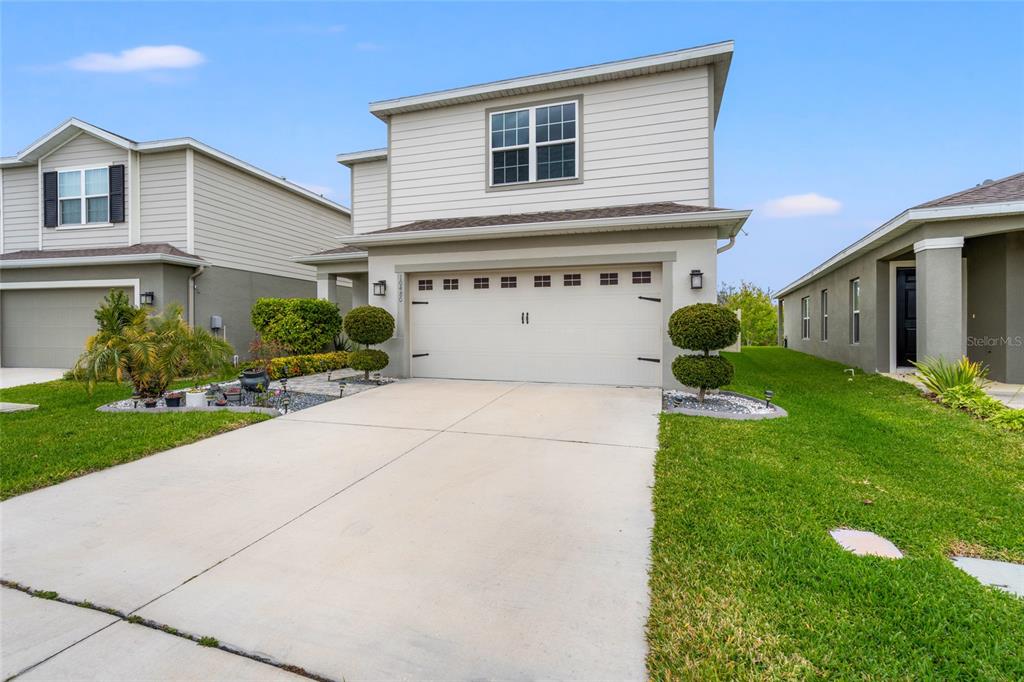 A two-story house with a beige stucco and siding exterior and a two-car garage — 10480 HAWKS LANDING DRIVE, LAND O LAKES, FL