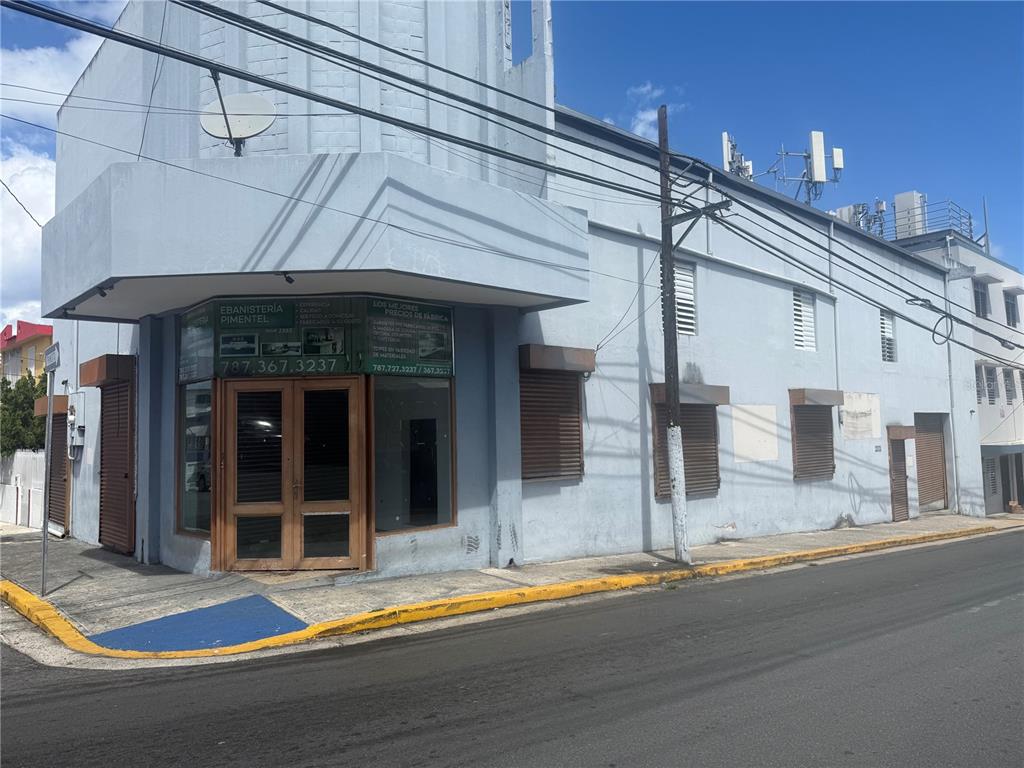 A light blue commercial building with a corner entrance and brown wooden shutters — 2121 EDUARDO CONDE, SAN JUAN, PR