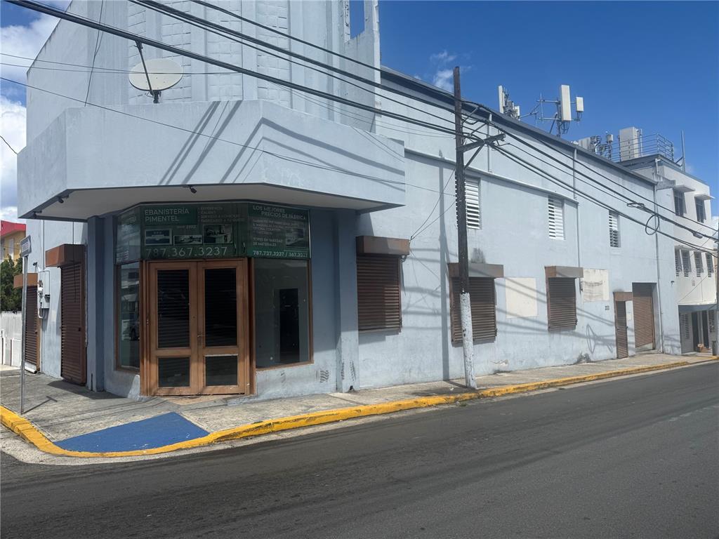 A two-story light blue commercial building with a corner entrance and brown roll-down shutters — 2121 EDUARDO CONDE, SAN JUAN, PR