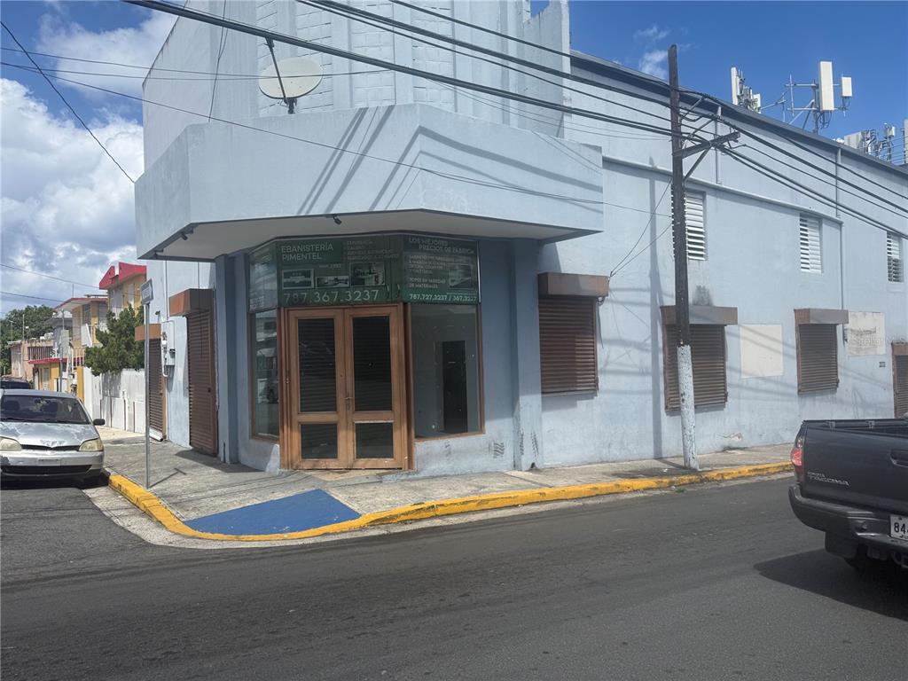 A corner commercial building with light blue walls, brown shutters, and a glass-paned entrance — 2121 EDUARDO CONDE, SAN JUAN, PR