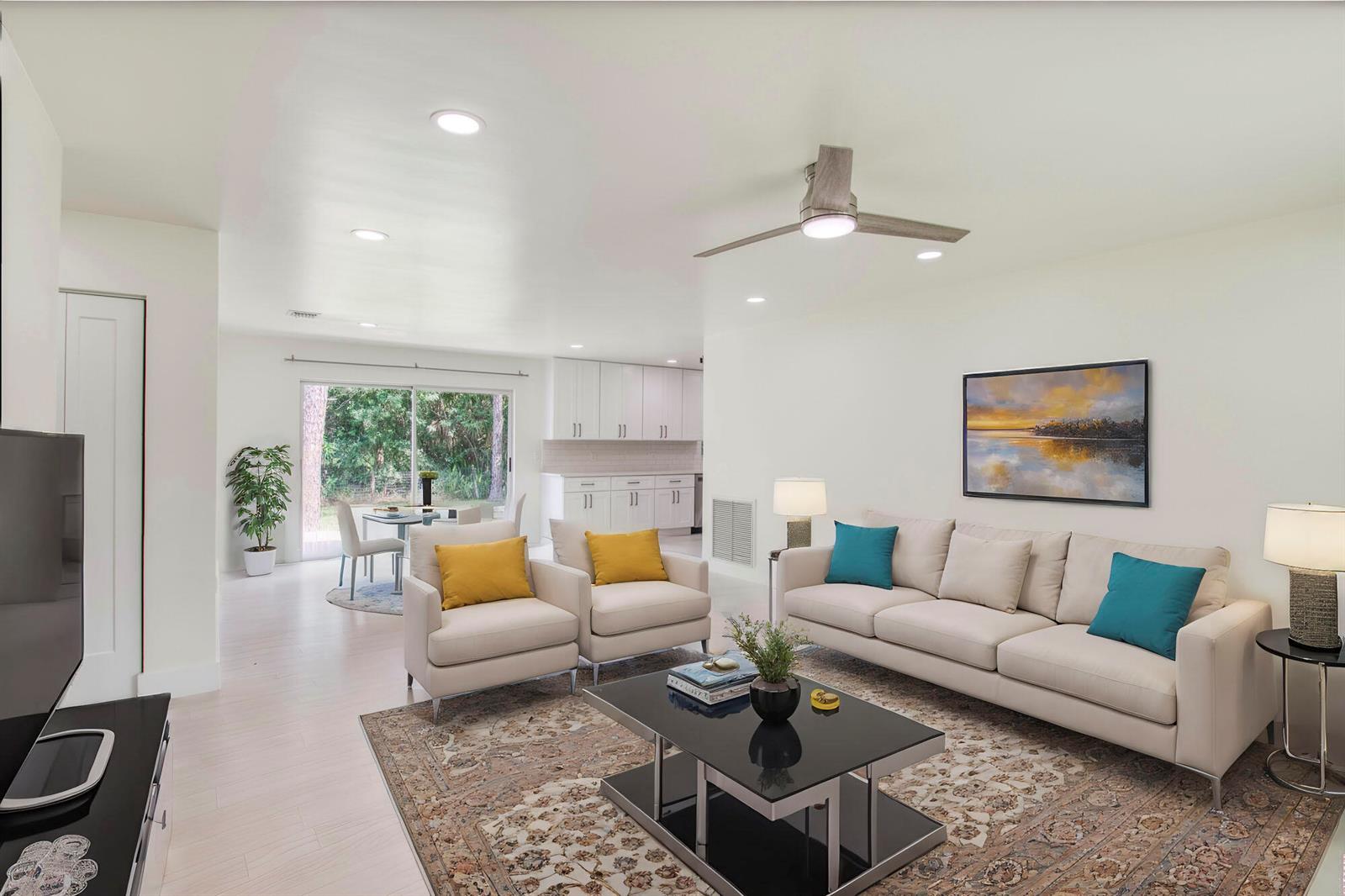 A bright living room features a beige sofa, two armchairs, and a dining area beyond — 14735 Flamingo Road, FL 33470, FL