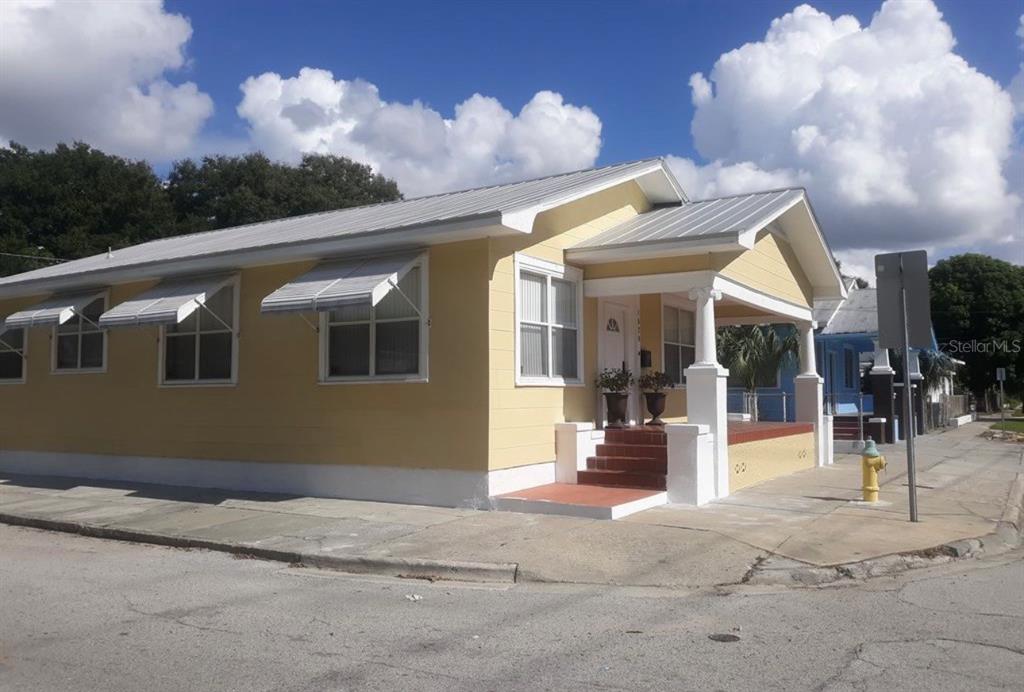 A yellow, single-story house with a metal roof and a covered front porch — 1520 E 21ST AVE, TAMPA, FL