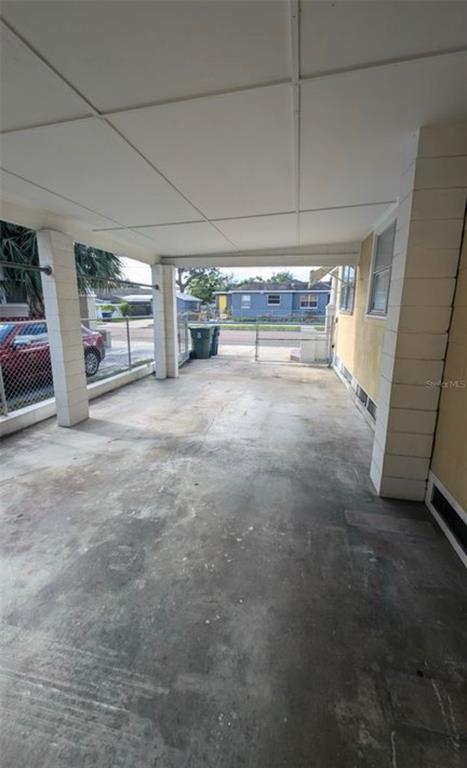 A covered concrete carport with white support pillars and a view of the street — 1520 E 21ST AVE, TAMPA, FL