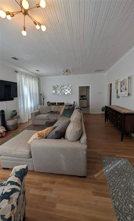 A living room features a large sectional sofa, wood flooring, and a white beadboard ceiling — 1520 E 21ST AVE, TAMPA, FL