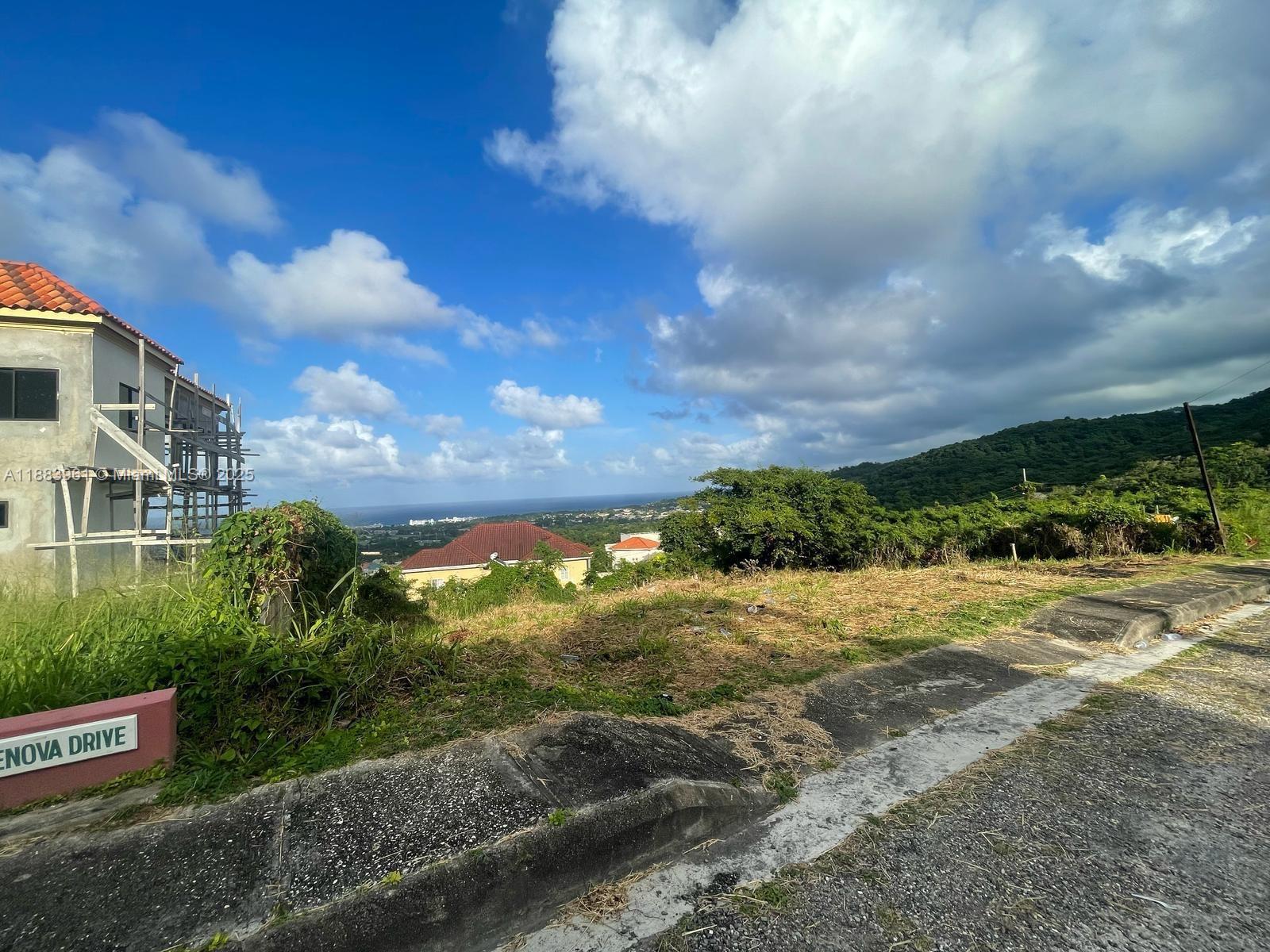 A vacant lot with a street sign sits next to a house under construction — 00 Vista Del Mar, Drax Hall St Ann Jamaica, NA, NA