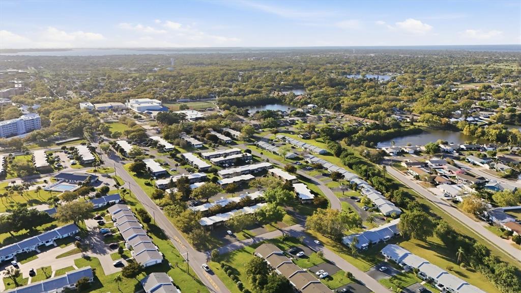 An aerial view shows a residential neighborhood with multiple apartment buildings, green spaces, and ponds — 3504 38TH STREET W, BRADENTON, FL